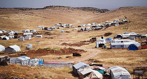 Refugee tents on dirt hillside