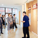 Conference members gathered together around posters in hall.