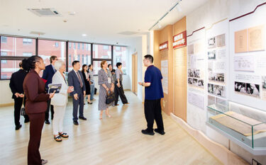 Conference members gathered together around posters in hall.