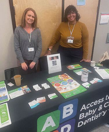 Heather Gallagher (left) and Gracemarie Cepero Lopez (right) at an Access to Baby and Child Dentistry (ABCD) booth.